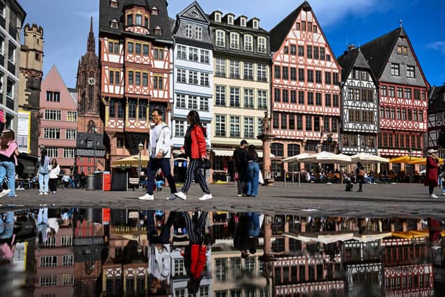 Tourists walk on the central Roemer Square in Frankfurt. (Photo by KIRILL KUDRYAVTSEV/AFP via Getty Images)