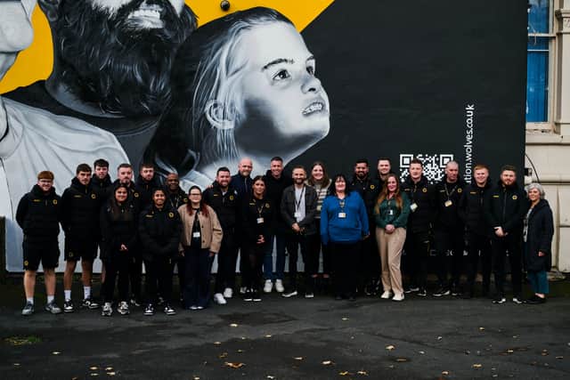 Foundation staff meet Head Coach Rob Edwards in front of the special mural, which emerged opposite Molineux in November.