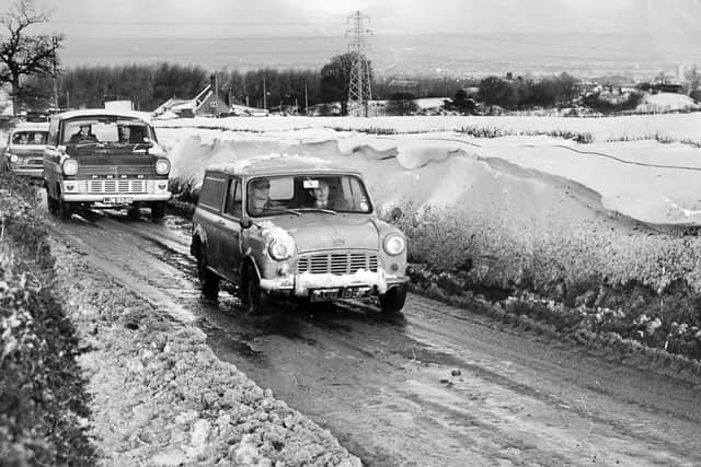 'The scene today on the Wellington to Dawley Road, where a 200-yard drift is thought to have covered several abandoned cars,' is the caption . The picture was taken on January 10, 1968, and published same day. The leading vehicle is a Mini van followed by a Ford Transit.