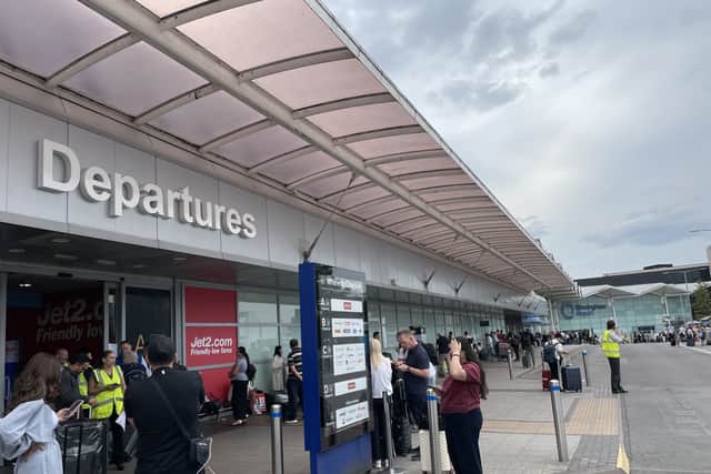 Passengers waiting outside departures at Birmingham Airport 
