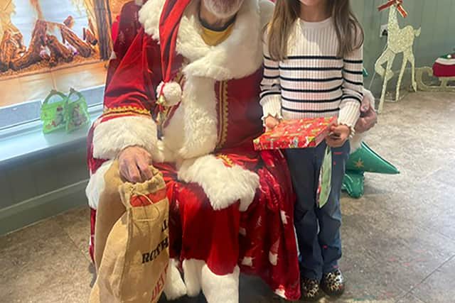 Resident Alan Bowater as Santa with child at HC-One’s Sedgley Court Care Home’s Christmas candy cane cavern