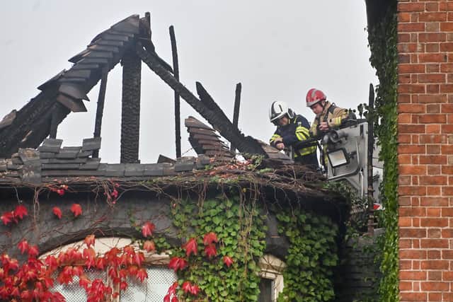 Firefighters inspect the roof after the blaze