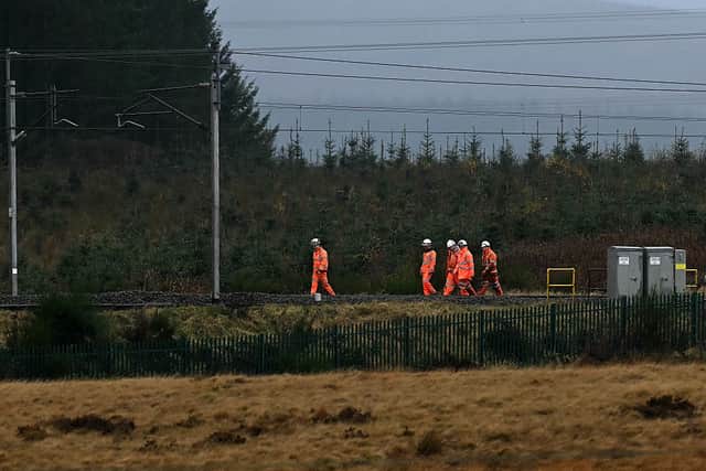 Network rail engineers walk along the track near to where an Avanti West Coast train, travelling from Glasgow to London Euston sation, derailed, near Shap, north west England on November 3, 2025.