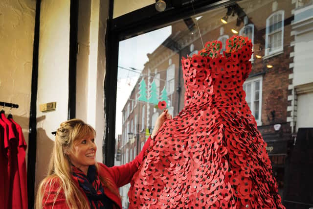 Taking a look at the window display dress, created from poppies, retail assistant Jo-Anna Maple of Church Stretton, at Marianne Exclusive Fashions, Shrewsbury in 2017