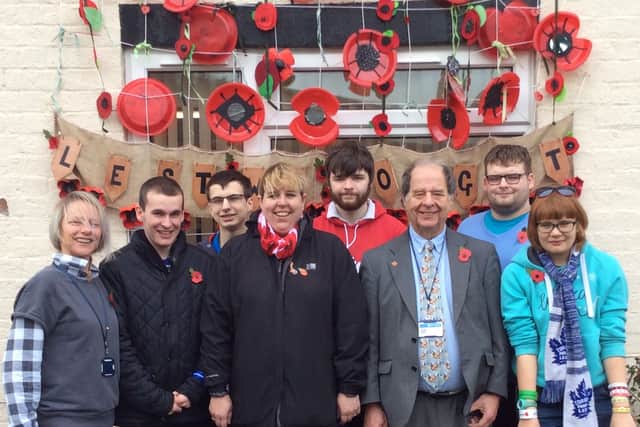 2018 - students from Derwen College create a Remembrance display in Craven Arms. In the picture: Claire Crippin and students Dan, Romain, Jos, Matt and Poppy stand with Councillors Sharon Demos and David Evans of Cyril Bason Ltd in front of the display