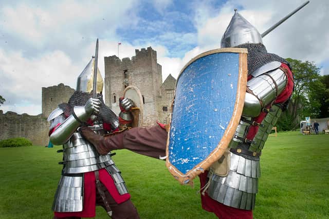 Ludlow Castle stands behind battling knights at a medieval day