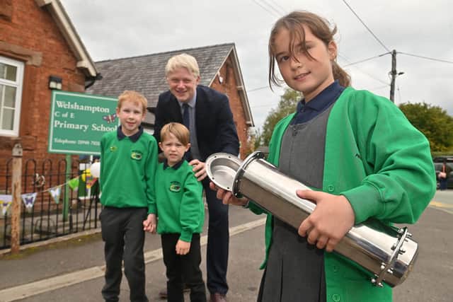Welshampton C of E School's headteacher Ben Crompton, with pupils Harry and Tate, along with Emma, who is displaying the time capsule to be buried as part of the anniversary. Photo: Steve Leath