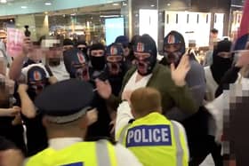 Video grab image issued by the Metropolitan Police of a clash between masked demonstrators and officers during an anti-illegal immigration protest in a Canary Wharf shopping centre
