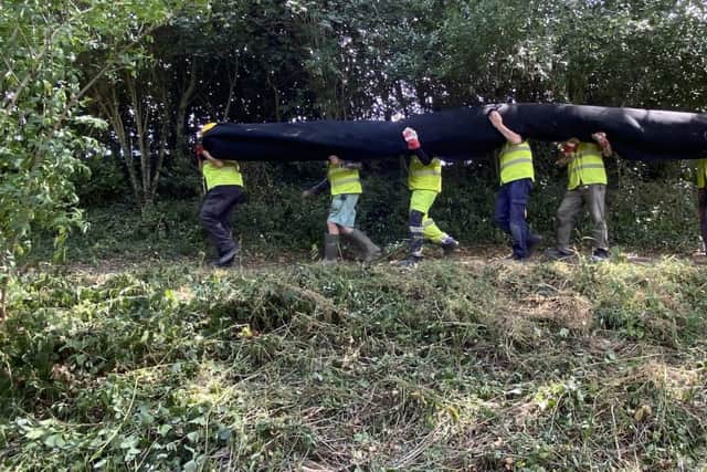 Carrying the canal liner. Photo: SUCS