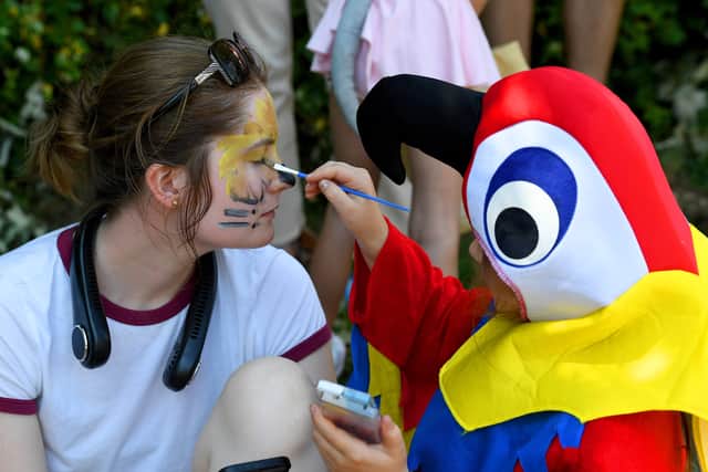 A face-painting parrot add a splash of colour to a carnival-goer