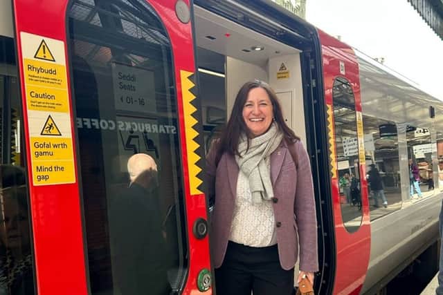Julia Buckley MP boarding a Transport for Wales train.