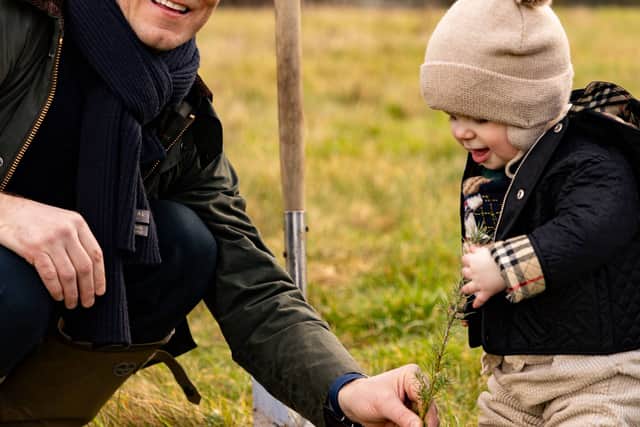 Alexander Newport of Bradford Estates joins the woodland planting watched by son Archie.