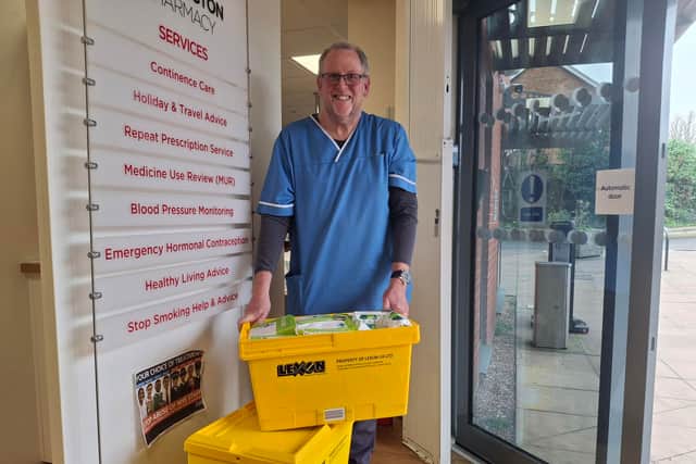 Conservative councillor Nigel Dugmore at the Donnington Pharmacy with a pile of four boxes of uncollected prescribed drugs. 