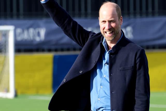 The Prince of Wales waves the linesman's flag during a mini football game at Sporting Khalsa FC in Willenhall