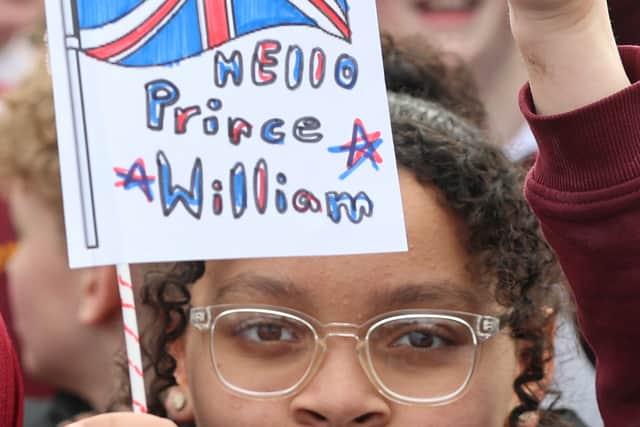 A pupil from Fibbersley Park Academy waves a Union flag with "Hello Prince William" written on it.