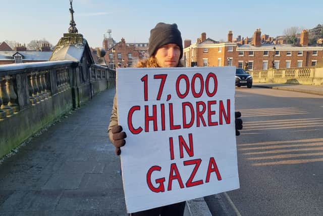 People stood on the bridge with different signs highlighting the ongoing crisis in Gaza. Photo: Andrea Bailey