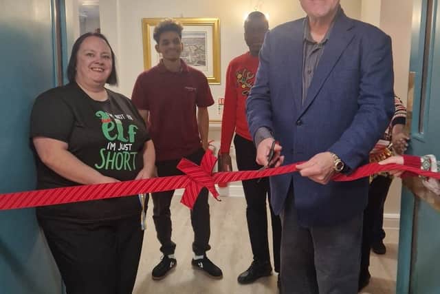 Andy Munro cuts the ribbon to reopen the Garden Suite