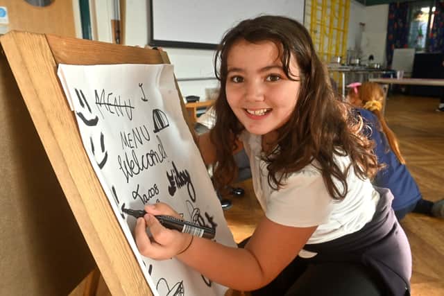 Layla Pope, nine, writes on the board for Coleham Primary School's Friday Night Dinner