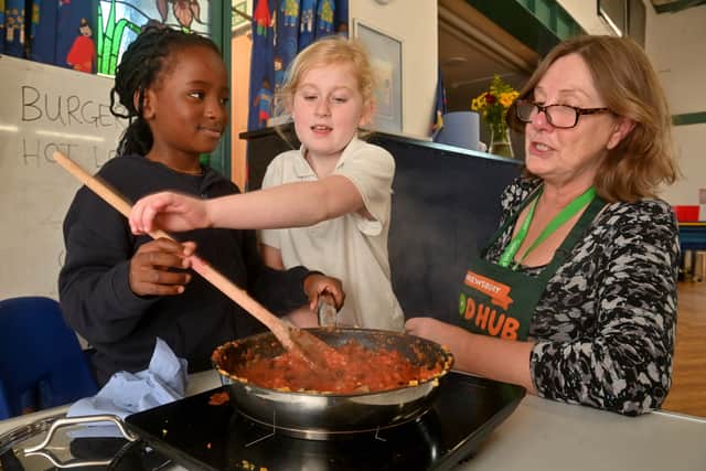 Shrewsbury Food Hub's Ali Thomas gets things sizzling with pupils Nicola Gundi, eight, and Olivia Gondwe Hart, nine