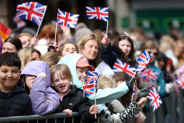 Members of the public await the arrival of Queen Camilla.