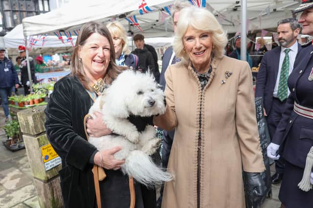 Queen Camilla (right) poses with a dignitary and her dog.