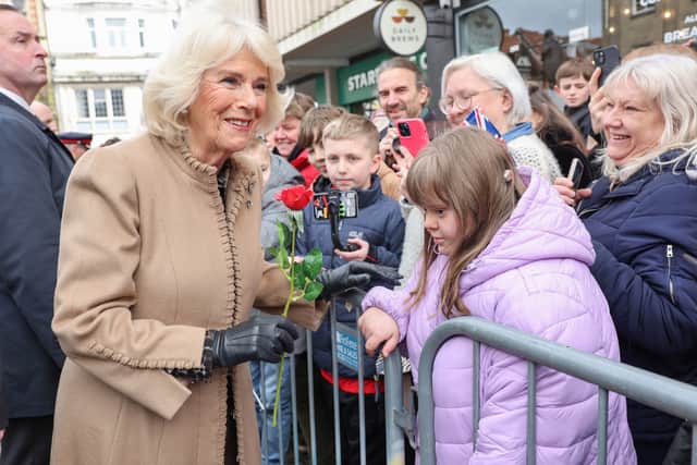 Another image of Queen Camilla smiling after receiving a red rose from Abi Crighton (second right).