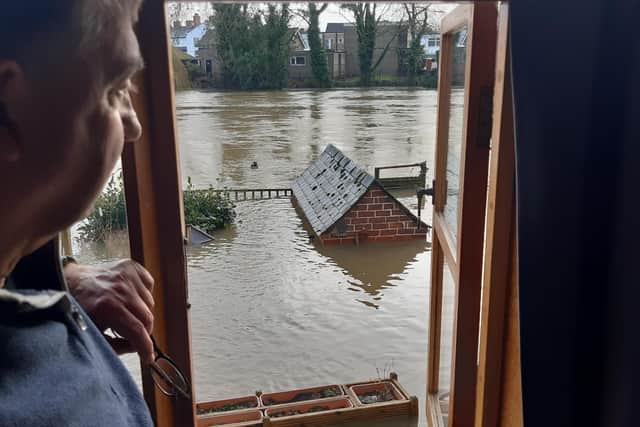 Terry Roberts looks out on his riverside back garden where the water was up to the roof of his shed and submerged his bird feeder