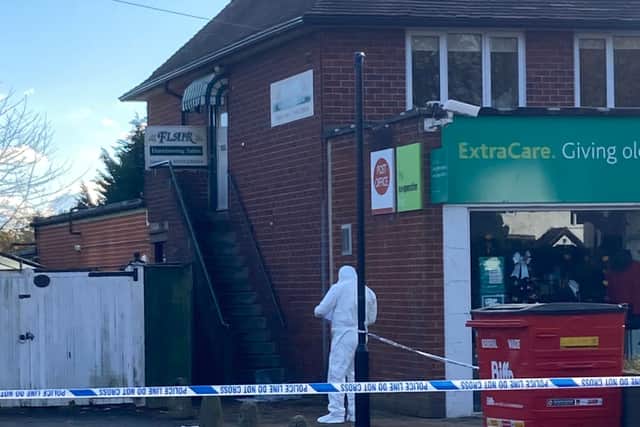 A forensic officer working at the side of the complex below the Flair hairdressing salon (Photo: Sue Austin).