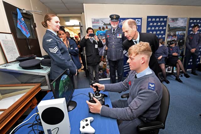 The Duke of Edinburgh watches Staff Corporal Declan Poole trying a flight simulator.