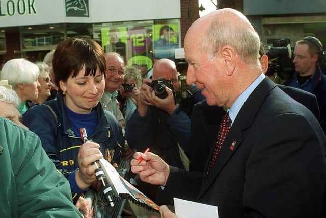Sir Bobby Charlton signing a football pennant for Angela Sawbridge from Willenhall after unveiling the Duncan Edwards statue in Dudley