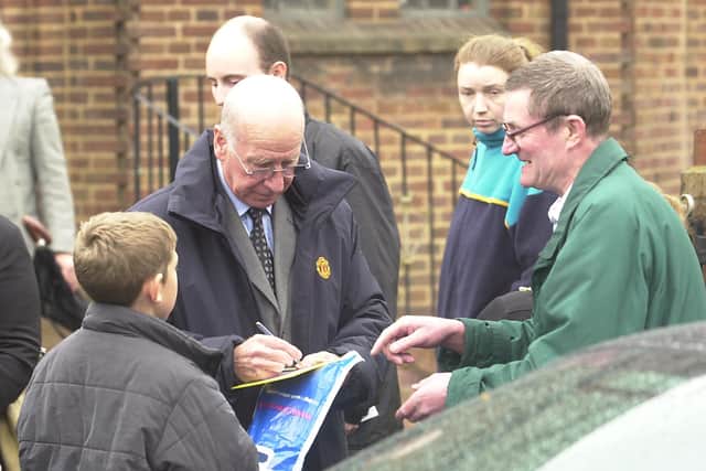 Sir Bobby Charlton signs autographs for fans at the funeral service of Sarah-Anne Edwards, mother of Duncan Edwards at St Francis's Parish Church in Dudley.