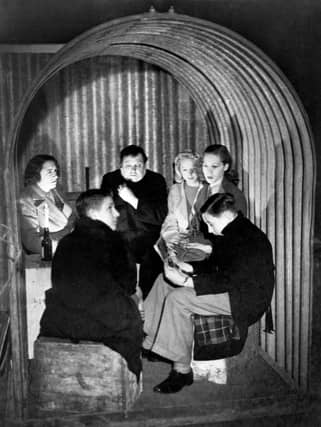 A family huddle in their corrugated iron Anderson shelter in London in 1940