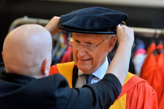 Bob Warman's rgaduation cap is adjusted as he prepares to be made an Honorary Doctor of Arts by the University of Wolverhampton.