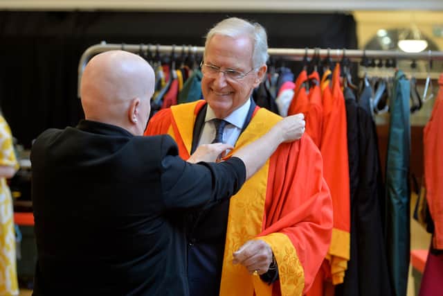 Bob Warman getting into his graduation robes as he prepares to be made an Honorary Doctor of Arts by the University of Wolverhampton.