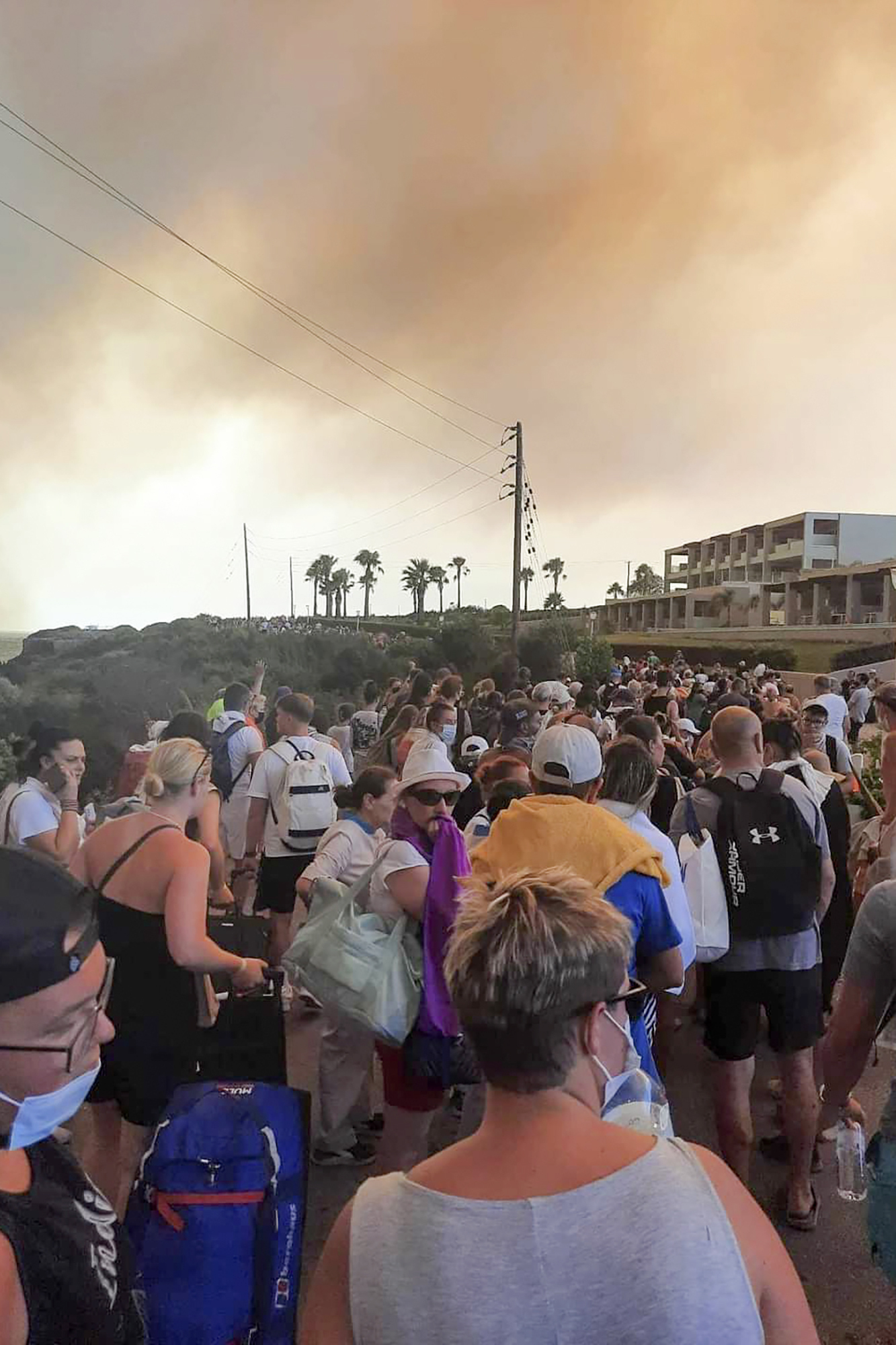 Tourists being evacuated during a forest fire on the island of Rhodes on Saturday. Photo: Rhodes.Rodos via AP.