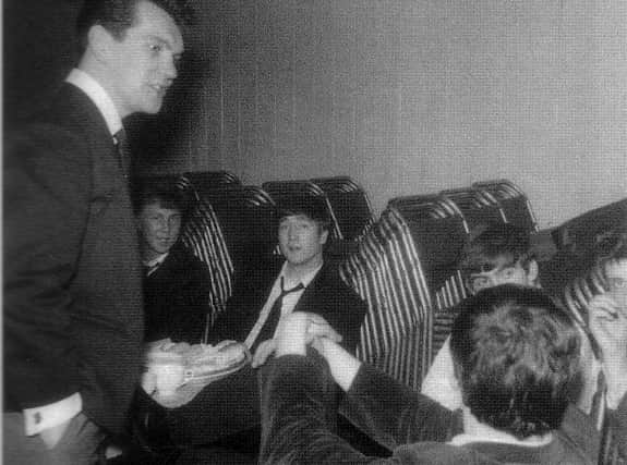 Jim Burgess, left, of Andre and the Electrons, chats with The Beatles.