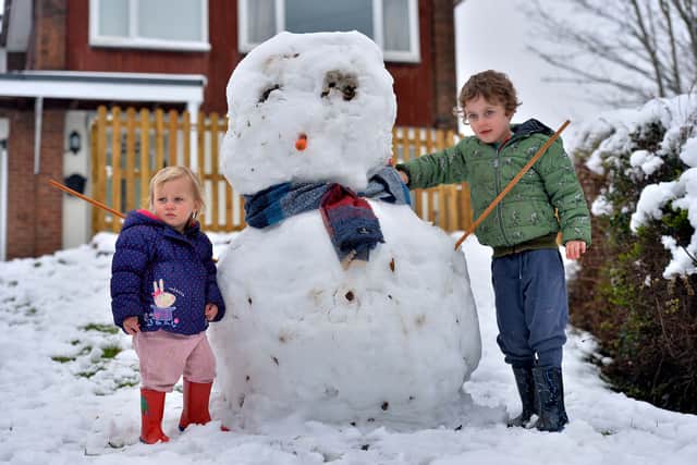 Grace (two) and Joey (four) Price and their snowman in St George's