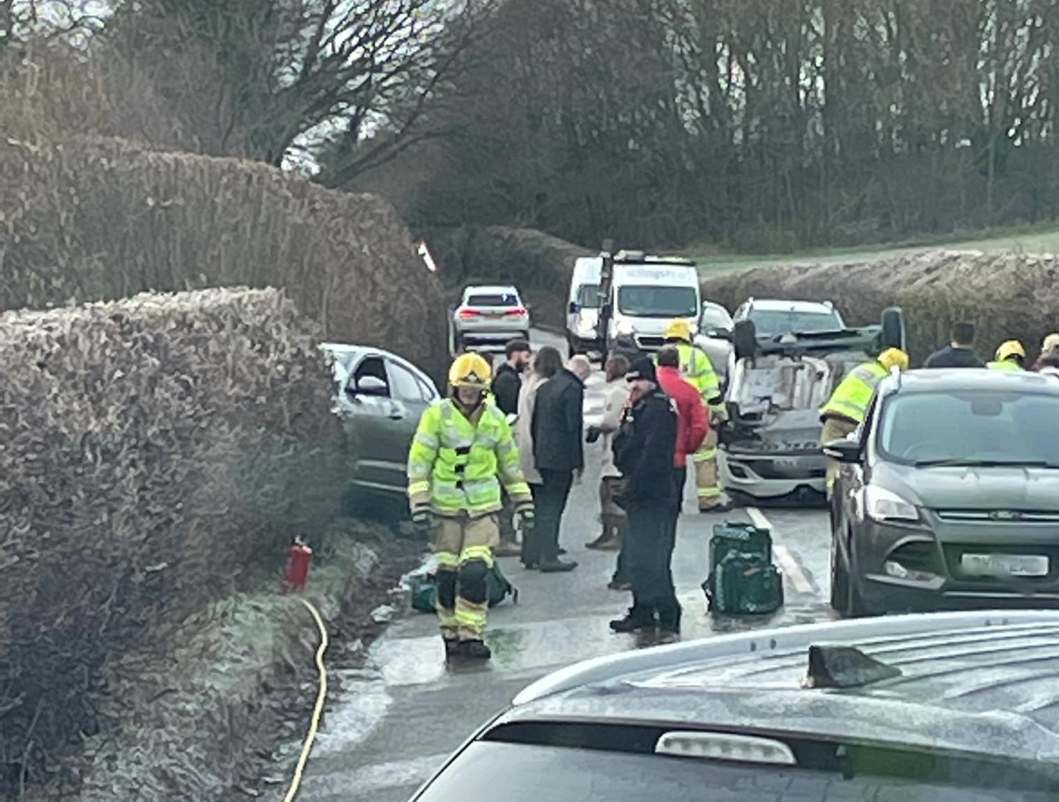 Crash 'caused by ice' leaves one car on its roof and another in a hedge