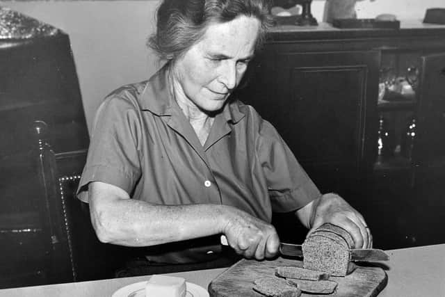 Dora Mayall cuts a slice of the organic bread in 1960.