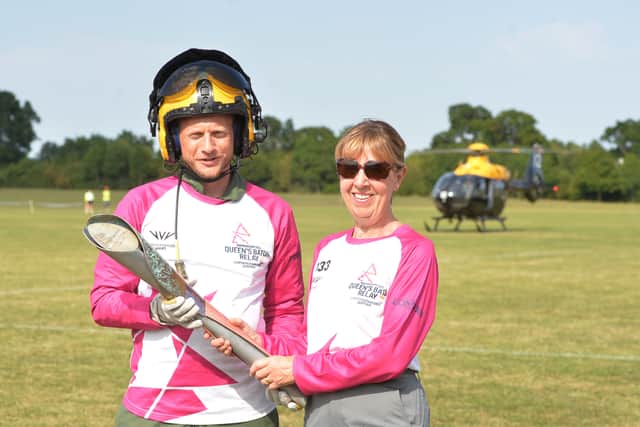 Matt Linghan from RAF Shawbury hands the baton over it over to Diane Morgan, from Shrewsbury