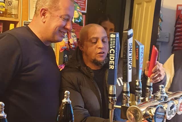 The World Cup winner has a go at pulling his own pint with landlord Richard Dixon
