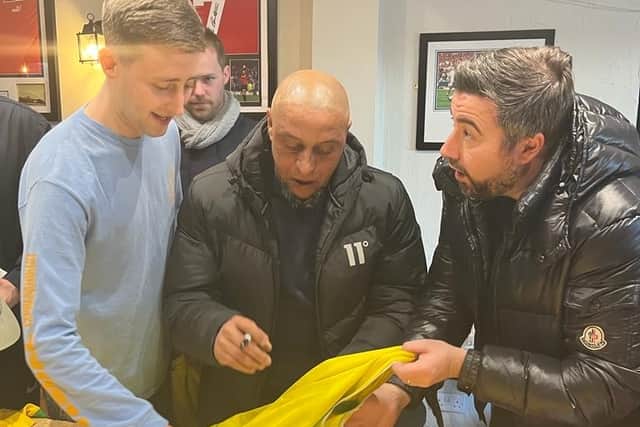 Carlos signing shirts at the pub