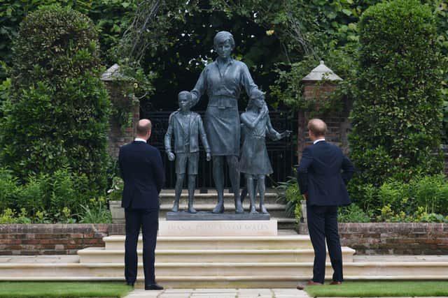 The Duke of Cambridge (left) and Duke of Sussex look at a statue they commissioned of their mother Diana, Princess of Wales, in the Sunken Garden at Kensington Palace, London, on what would have been her 60th birthday.