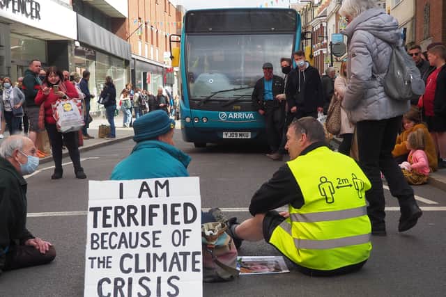 An Arriva employee sitting with the protester. Photo: Phil B