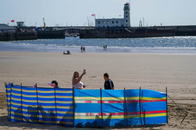 A family gather on the beach in Scarborough, England. (Photo by Ian Forsyth/Getty Images)