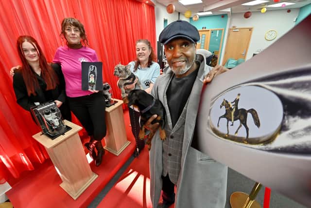 Wednesfield-born sculptor Willard Wigan visited Halesowen to help raise funds for, and launch the community hub of, Monarch's Mutts Dog Rescue. He also showed off his latest sculpture, a Peaky Blinders character on a horse. Pictured with Willard are Mitzie the dog and, from left: volunteer Brodie Sadler, founders Lucy and Kate Antill with dog Tiny Tim. Photo: Steve Leath