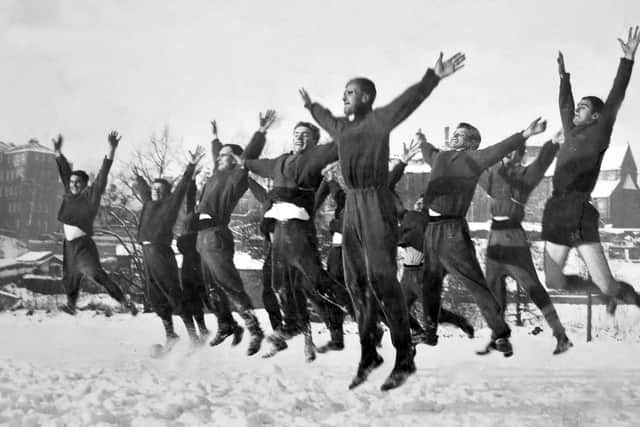 Shrewsbury Town players in training in the snow on New Year's Day in 1962. The caption reads: 'The 'ups and downs' of the football world, depicted by the Shrewsbury Town players as they limbered up in preparation for their cup match at Southport.'