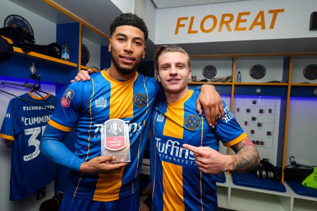 Josh Laurent and Jason Cummings celebrate with the man of the match trophy in the changing rooms