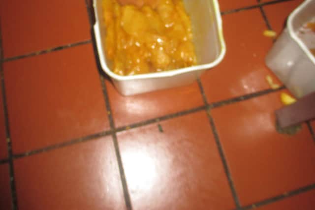 Marinated chicken left in a plastic container on the floor