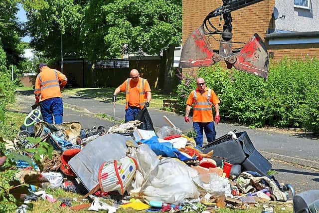 A team of council workmen clearing away a large pile of rubbish that was fly-tipped at Stebbings in Sutton Hill, Telford